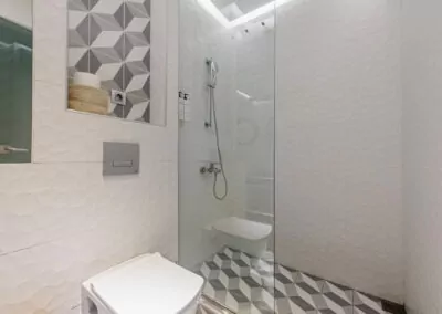 Modern marble bathroom with walk-in rain shower and luxury amenities at Alpha Luxury Suites