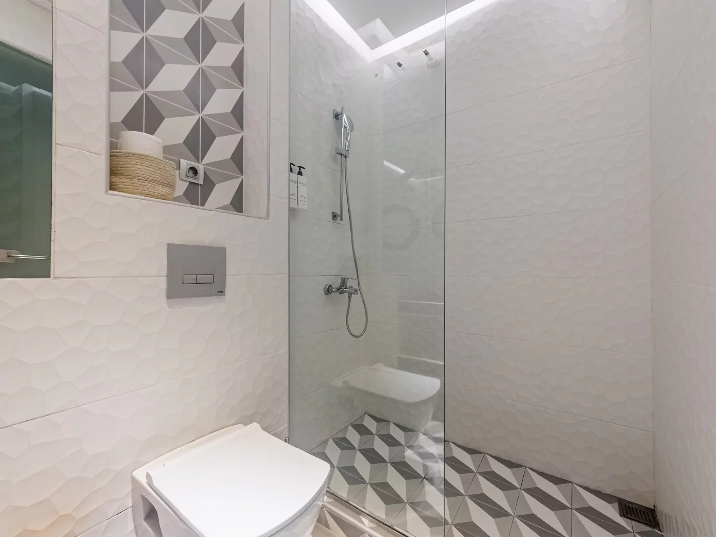 Modern marble bathroom with walk-in rain shower and luxury amenities at Alpha Luxury Suites