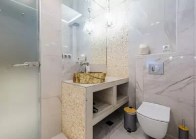 Modern marble bathroom with walk-in rain shower and luxury amenities at Alpha Luxury Suites