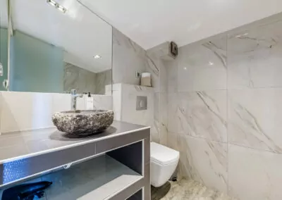 Modern marble bathroom with walk-in rain shower and luxury amenities at Alpha Luxury Suites
