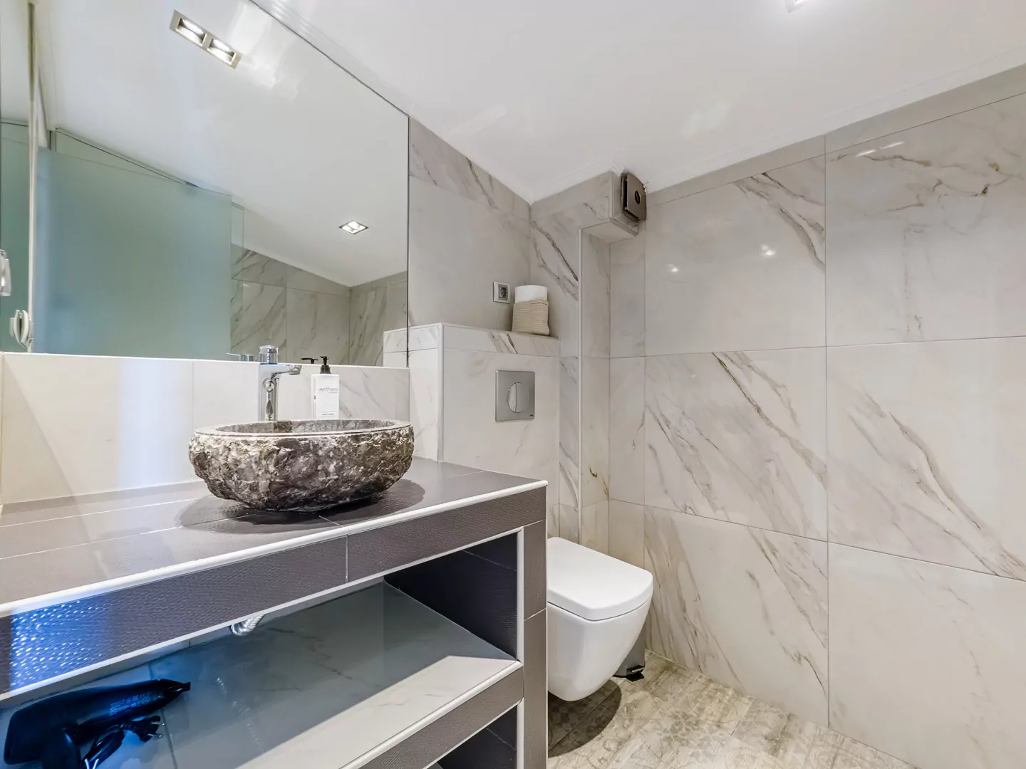 Modern marble bathroom with walk-in rain shower and luxury amenities at Alpha Luxury Suites