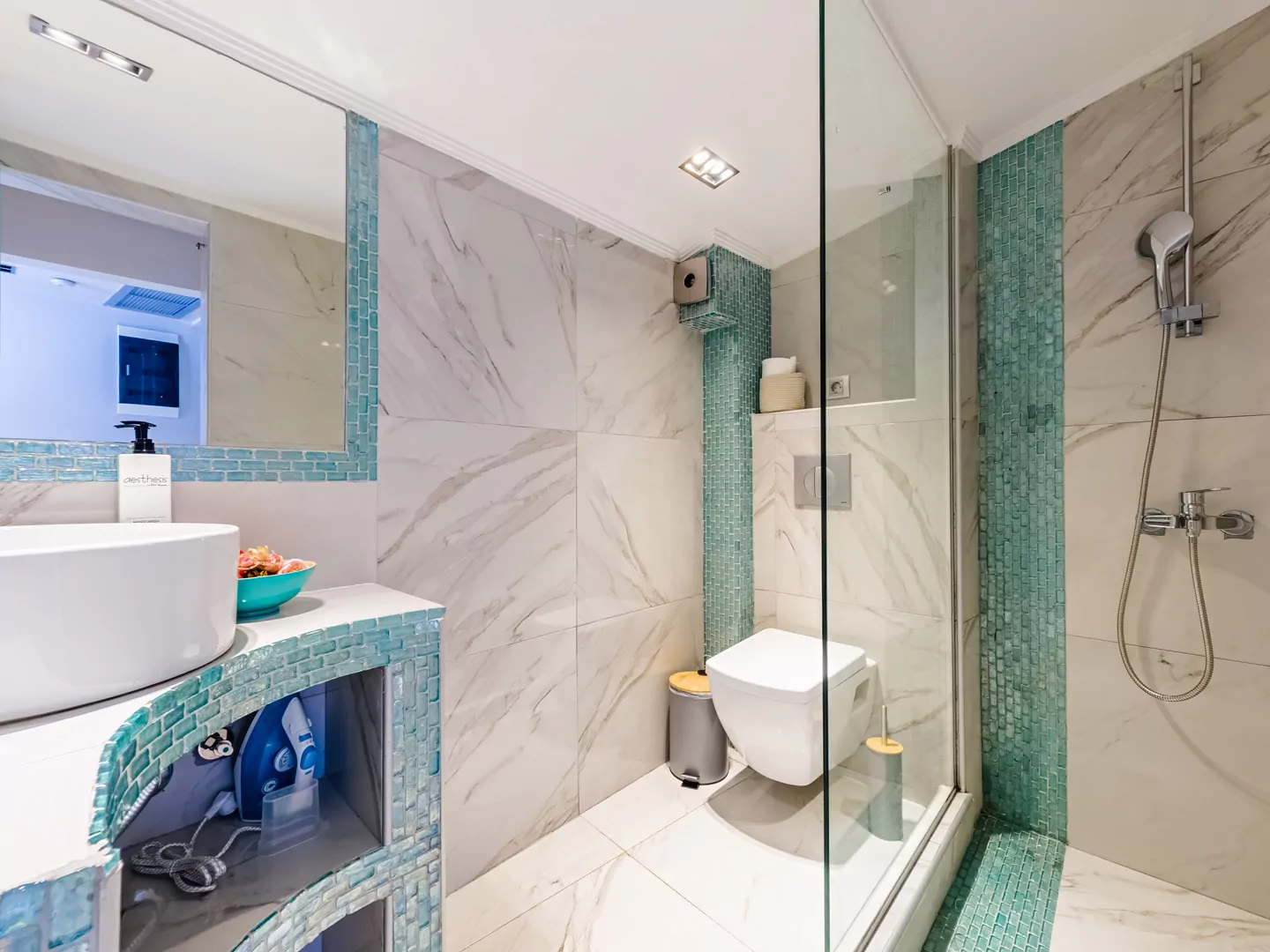 Modern marble bathroom with walk-in rain shower and luxury amenities at Alpha Luxury Suites