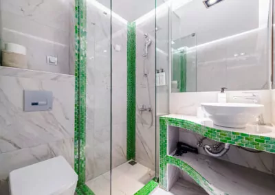 Modern marble bathroom with walk-in rain shower and luxury amenities at Alpha Luxury Suites