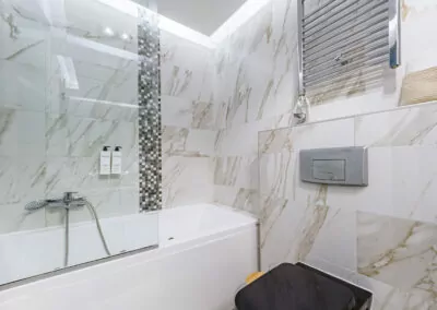 Modern marble bathroom with walk-in rain shower and luxury amenities at Alpha Luxury Suites