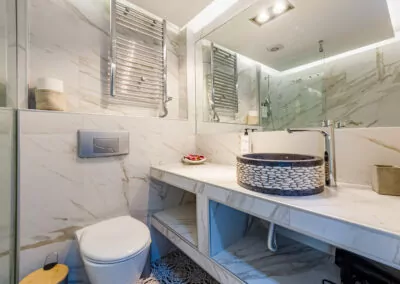 Modern marble bathroom with walk-in rain shower and luxury amenities at Alpha Luxury Suites