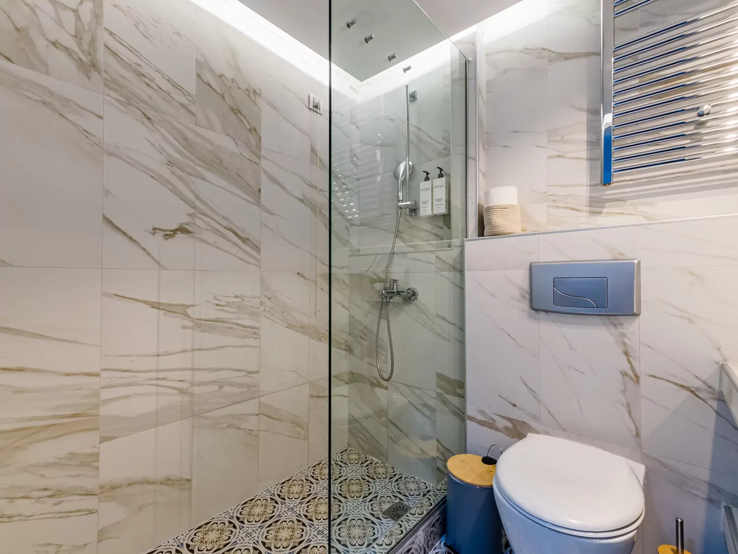 Modern marble bathroom with walk-in rain shower and luxury amenities at Alpha Luxury Suites