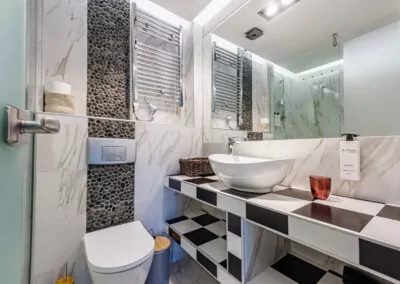 Modern marble bathroom with walk-in rain shower and luxury amenities at Alpha Luxury Suites