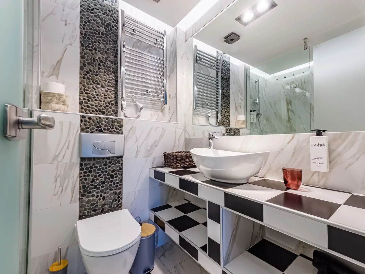 Modern marble bathroom with walk-in rain shower and luxury amenities at Alpha Luxury Suites