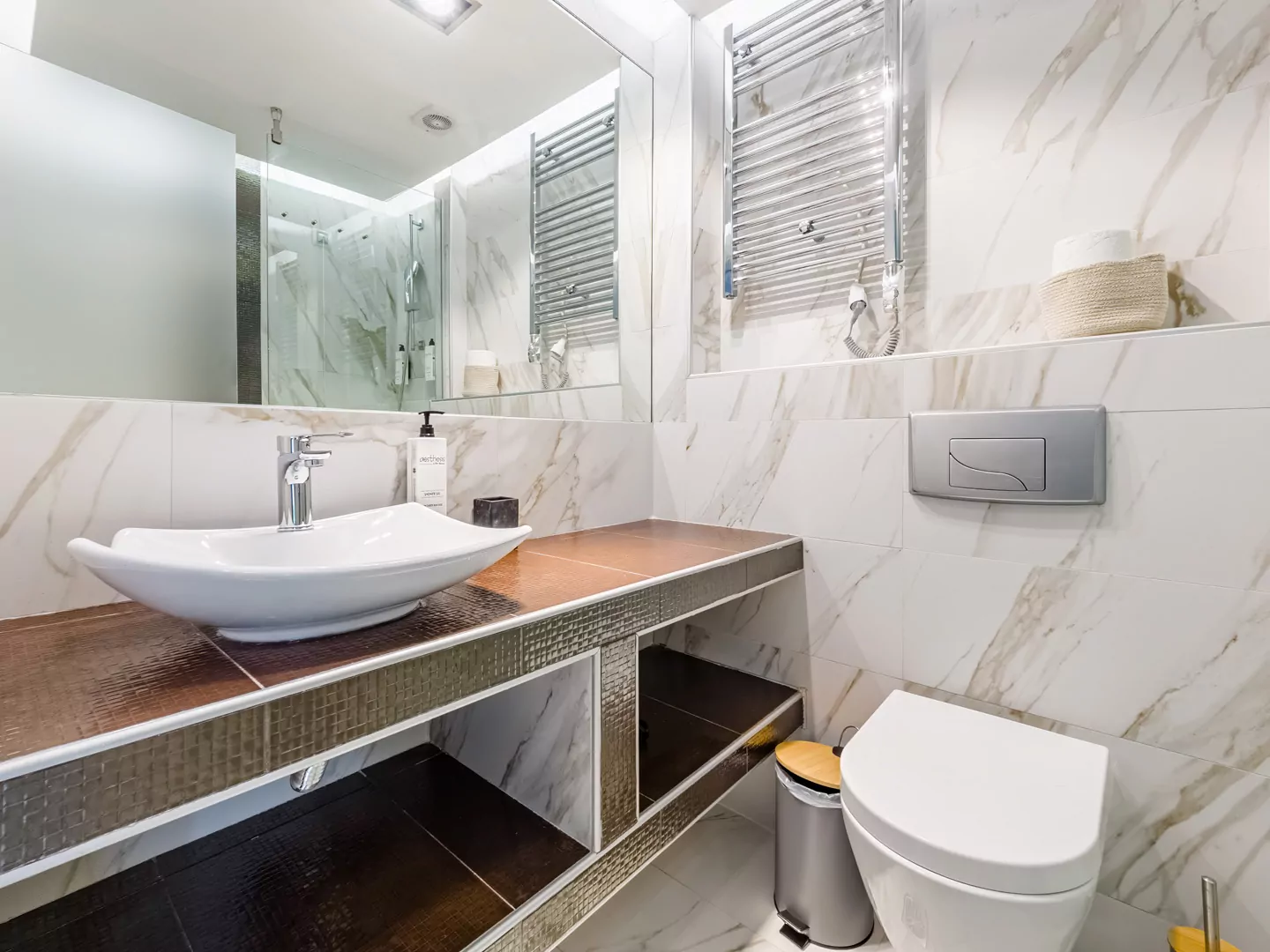 Modern marble bathroom with walk-in rain shower and luxury amenities at Alpha Luxury Suites