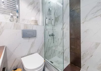 Modern marble bathroom with walk-in rain shower and luxury amenities at Alpha Luxury Suites