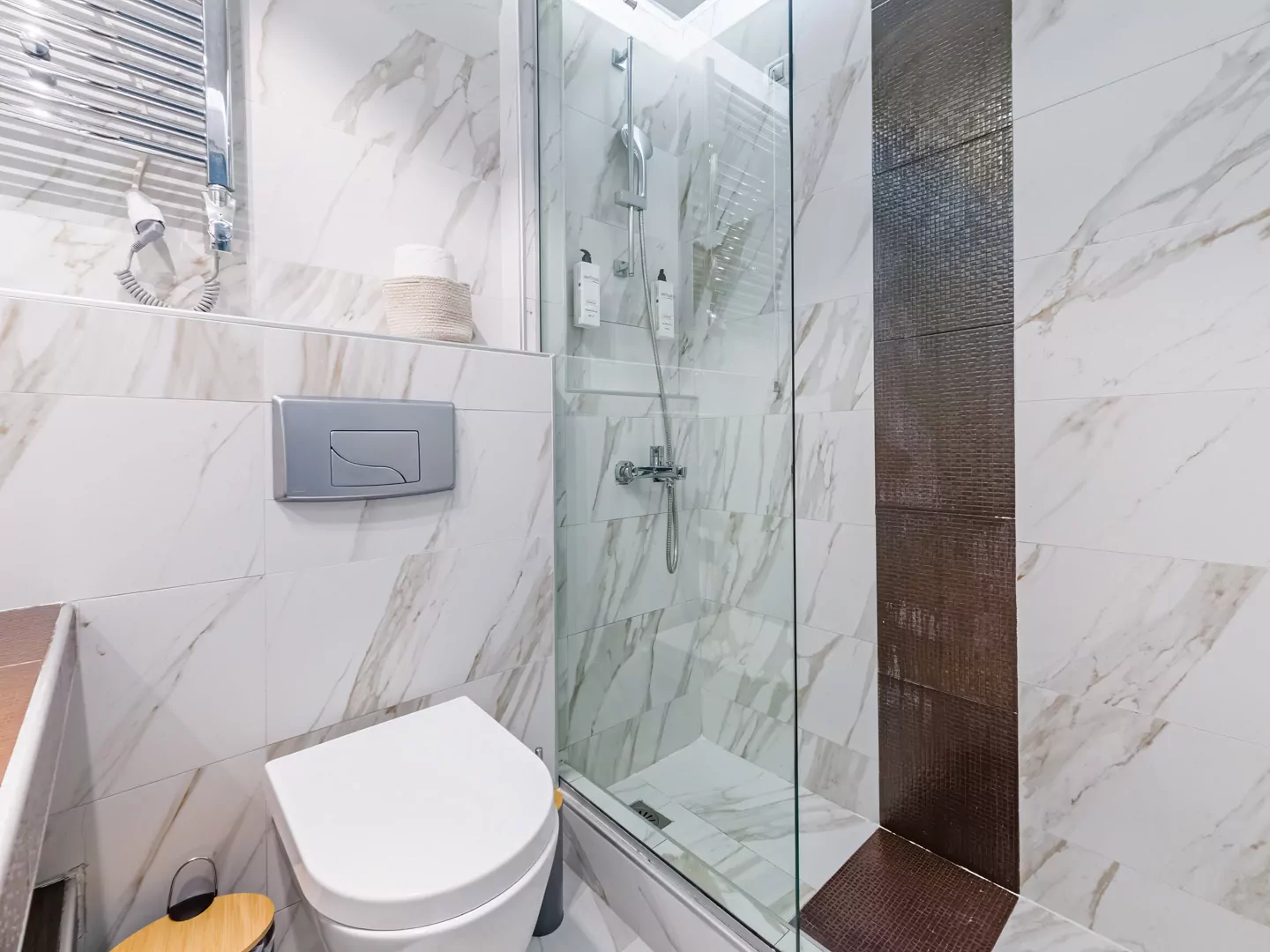 Modern marble bathroom with walk-in rain shower and luxury amenities at Alpha Luxury Suites
