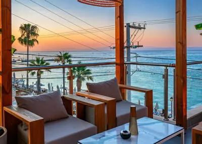 Sunset view from Alpha Luxury Suites Rooftop Bar in Pefkohori with sea view and cocktails